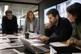A team of cybersecurity experts discussing a security report in an office setting.