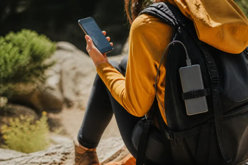 The Xiaomi 5000 15W is magnetically attached to a smartphone during a travel scenario.