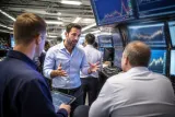 A group of traders analyzing Bitcoin price trends at a trading desk.