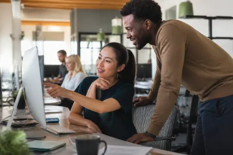 A modern office workspace featuring collaborative AI technology and employees