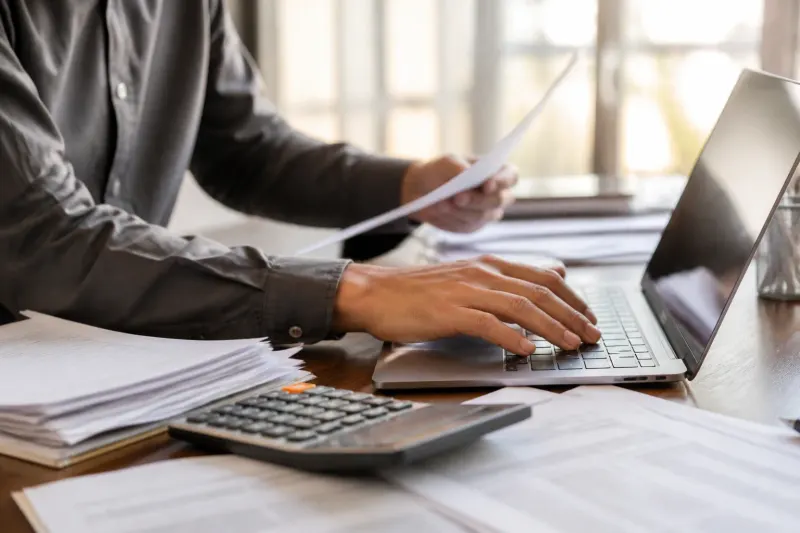 A close-up of hands working on financial models and data analytics tools.