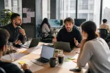 A group of traders discussing strategies around a table in an office.