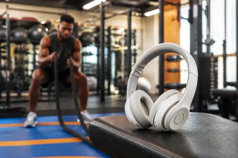 Beats 360 headphones displayed in a workout setting with vibrant colors and dynamic background.