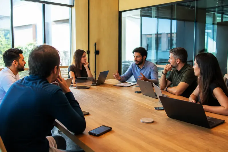Industry experts discussing in a conference room about Bitcoin’s market trends.