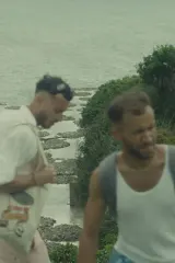 Poster for The Lament of Spice Island (2026) showing two young men on a sunlit island shore with spice market colors in the background
