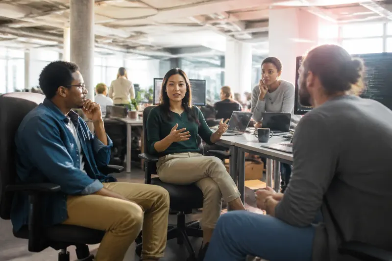 A team of IT professionals discussing security measures in a bright office.