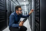 A technician auditing a server rack in a data center.