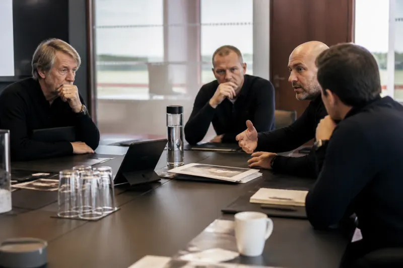 Manchester United staff discussing potential coaches in a meeting room.