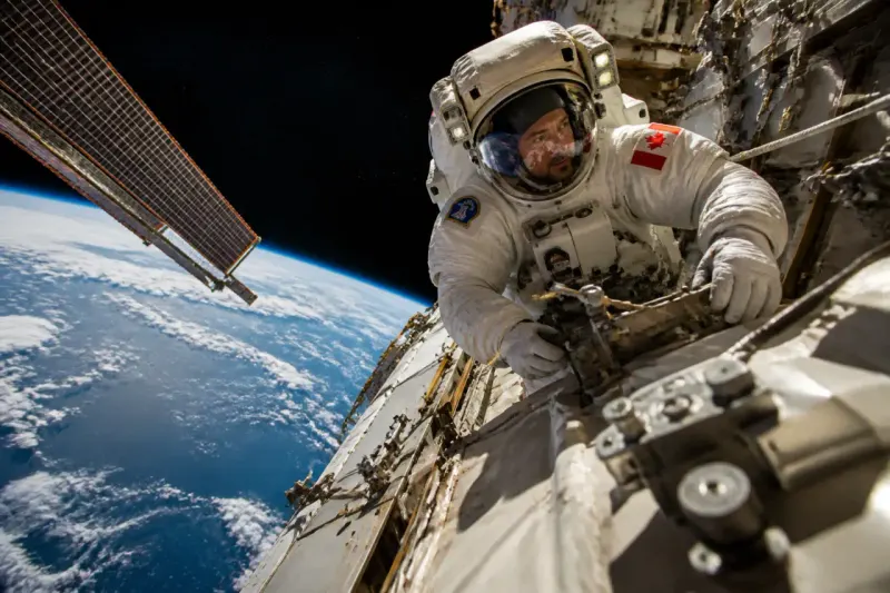 Joshua Kutryk preparing for a spacewalk outside the ISS in a spacesuit.