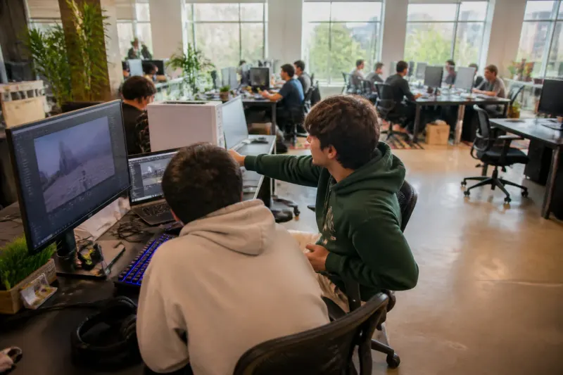 A developer working on a game at a coworking space with a laptop.